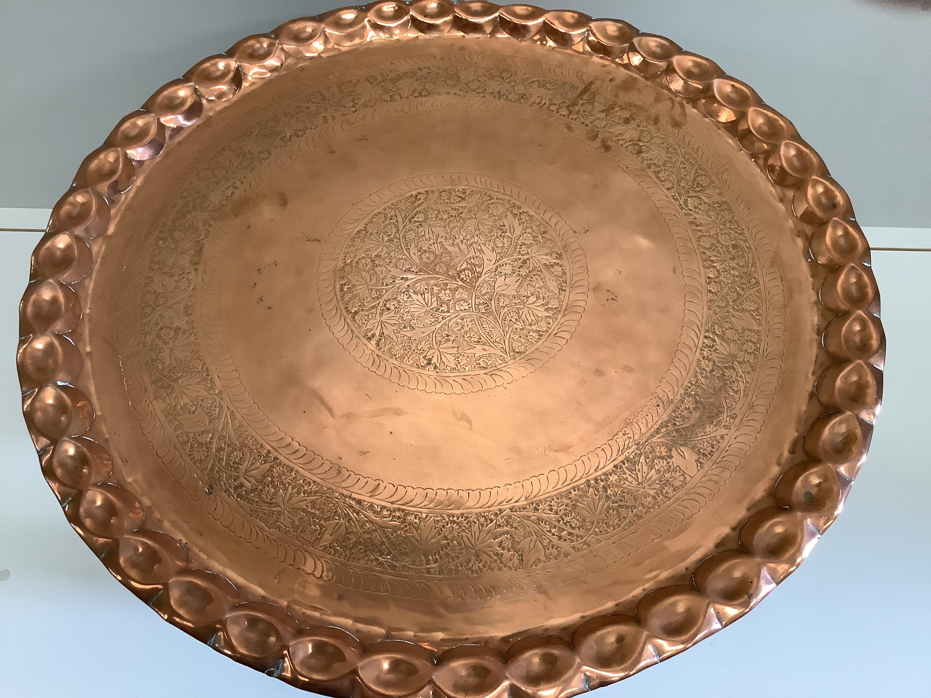 A Moorish circular copper tray top occasional table on folding stand, diameter 77cm, height 53cm